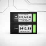 TickrMeter E-Ink display showing live Bitcoin and stock market prices on a minimalist desk